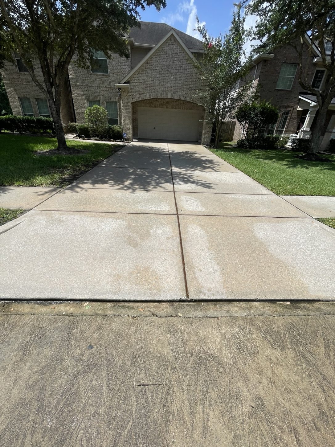 After pressure washing: visibly cleaner residential driveway