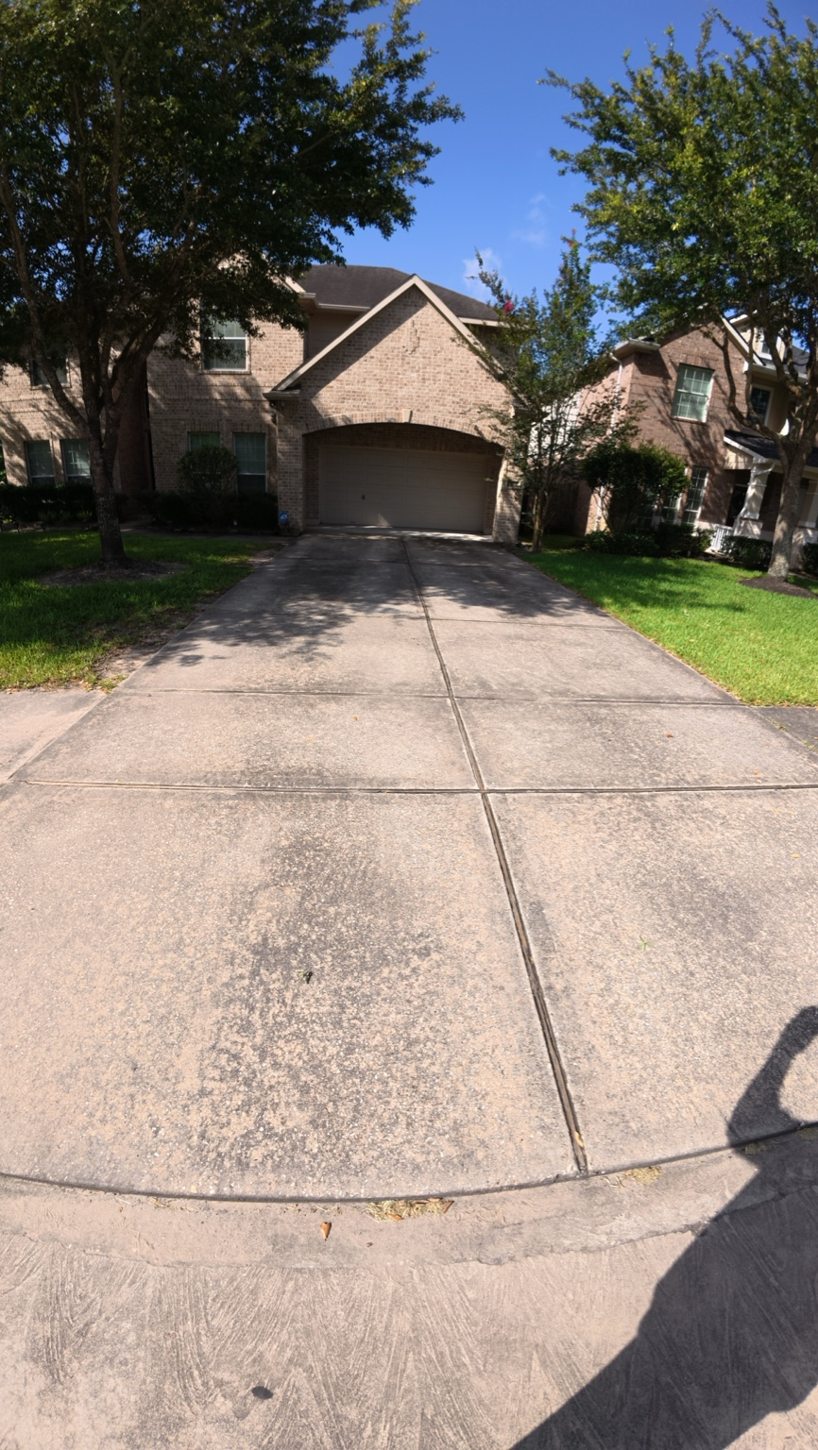 Before pressure washing: residential driveway with dark staining